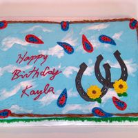 Horseshoe Cake Bc frosting clouds & grass w/ fondant horseshoe, rope, & paisleys