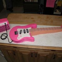 Pink Electric Guitar This is my first carved cake. It is for my DD 12th birthday. The body of the guitar is vanilla, the neck is chocolate and the amp is...