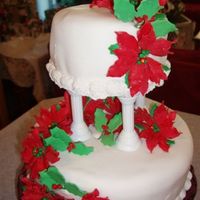Poinesettia Cake The bottom tier is white cake with chocolate buttercream filling, iced in vanilla buttercream and Pettinice fondant. The top tier is butter...