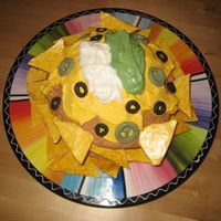 Plate Of Nacho's Cinco De Mayo cake-- Plate of nacho's. White cake with caramel filling. Olives, jalapeno's and tortilla chips are fondant, rest...