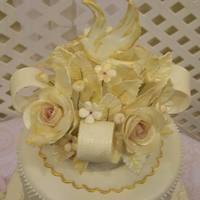 Sugar Vase And Flowers This cake topper features a sugar bowl filled with gumpaste flowers, leaves, ribbons and a royal icing dove.