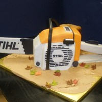 Chain Saw 3-d Chain saw. cake carved & stacked around center support for wooden blade. All covered in MMF. The 'handle' is actual...