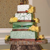 Fall Theme Wedding Cake 4 tier square custom designed around elements from bride's reception. Cake covered in MMF, non-edible ribbon to match reception. Bride...