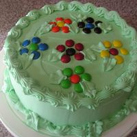 M & M Flower Cake This cake is made with a whipped frosting. The candies are m and m's that are made into flowers.