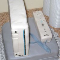 Wii Cake 8" square cake covered in MMF. Rice Crispy cake carved in shape of Wii and controller, both covered in Wilton fondant.