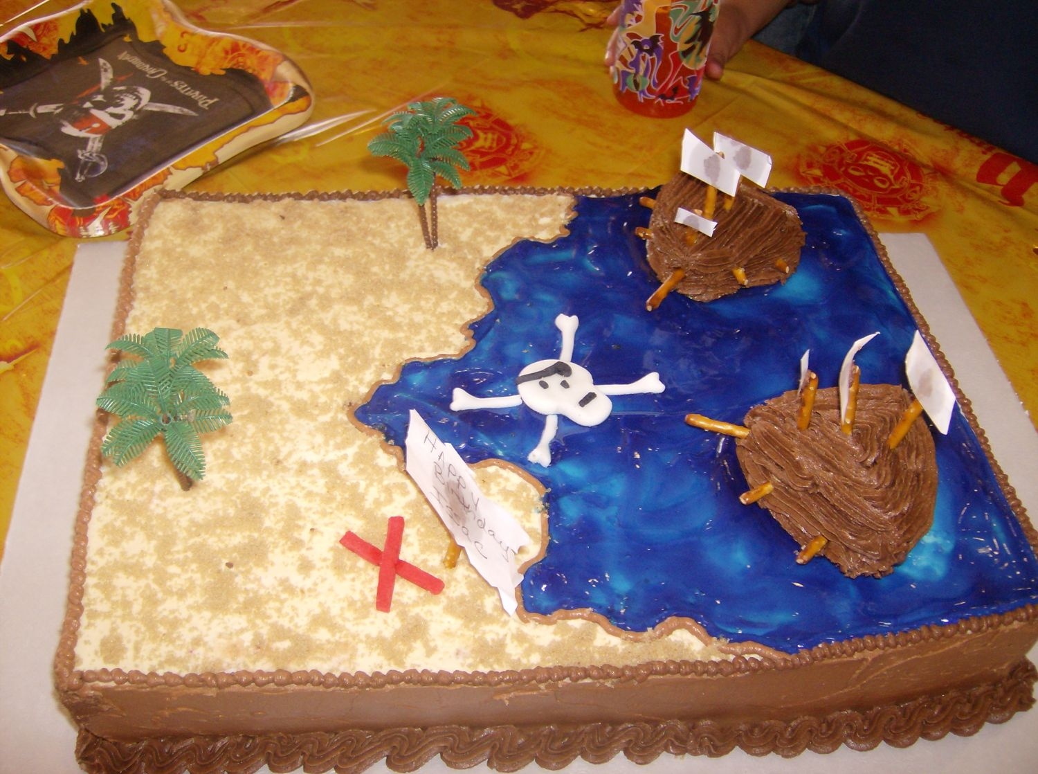 Pirate Cake ocean made of piping gel and the ships made of gram crakers and icing inbetween them.and brown sugar sprinkled over tan icing.im missing...