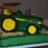 John Deere Tractor Vanilla sheet with vanilla cake tractor base. Tires are rice crispies. Tractor cake board is elevated on styrofoam pillars. Graham cracker...