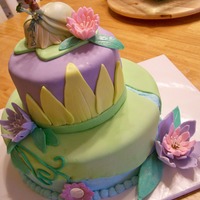 Princess And The Frog This was such a fun cake. 10" and 6" chocolate cake with buttercream frosting and MMF. Flowers are fondant dried overnight.