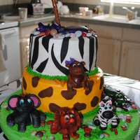 Safari Theme Cake This was for a safari themed 1st birthday! The cake was iced in butter cream and had fondant accessories and fondant animals!