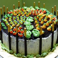 Garden Cake Chocolate cake with french buttercream. Veggies are piped with french buttercream & chocolate pretzel sticks as fences.
