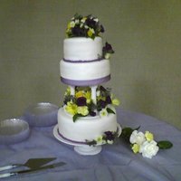 Amber's Wedding Cake This has real flowers on it. It is chocolate on the top and bottom and strawberry in the middle. Fondant icing and ganash filled chocolate...
