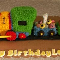 Lennox's 1St Birthday Cake An almond pound cake, with 2 carriages. Chocolate "flake" bars for logs and lollies for cargo.