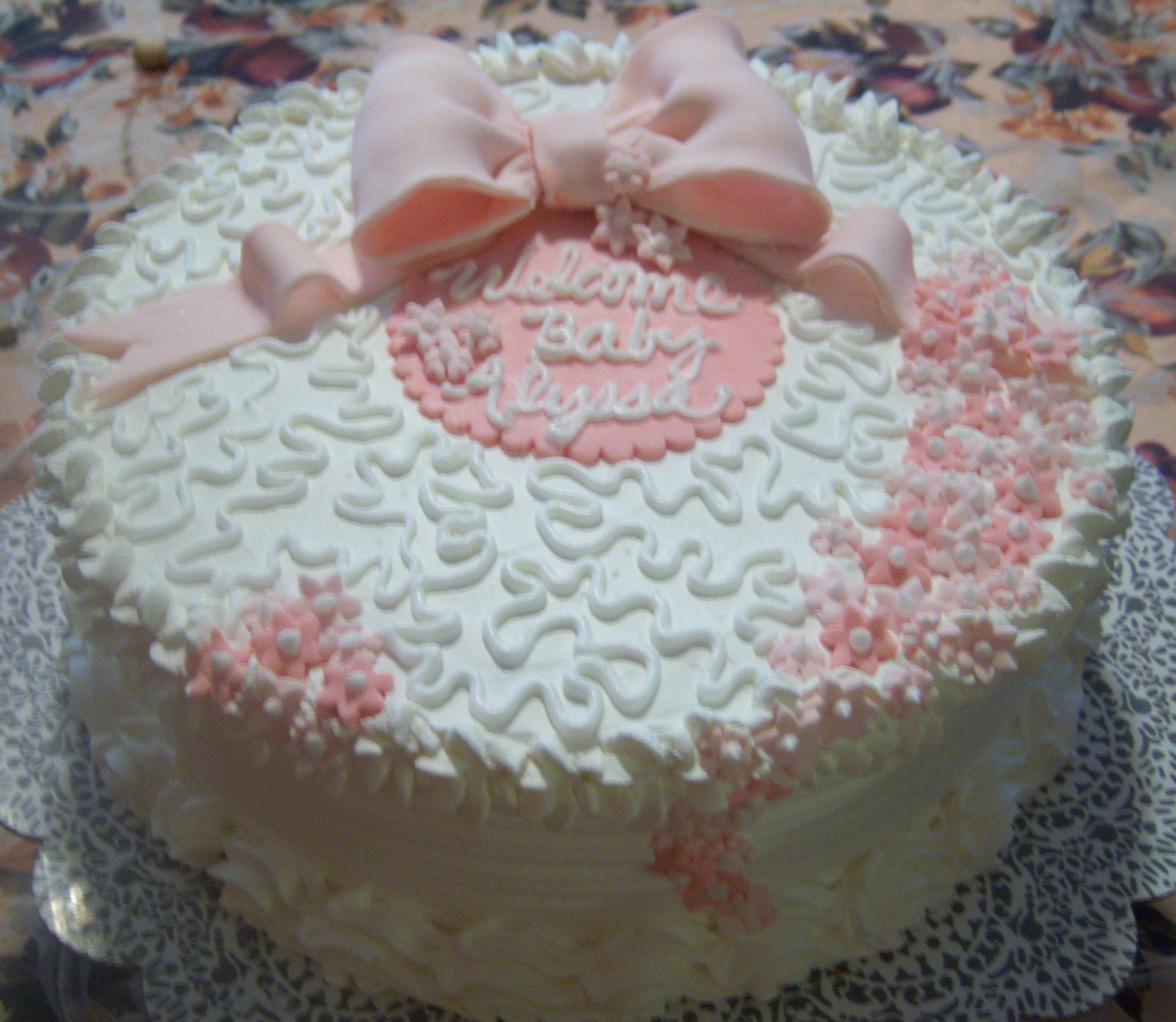 Baby Girl White cake with fresh strawberries and cream filling. Iced with whipped cream icing and fondant accents.