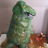 T-Rex Dinosaur Cake Made for a friend's Birthday. :) The head, legs and tail are rice krispie treats... The rest is cake. :) Fondant figure, fire, etc...