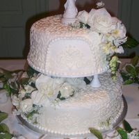 First Wedding Cake covered in fondant and adorned with artificial flowers. this cake took me 14 hours to make and decorate.this was my first wedding cake and...