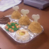 T.v. Dinner Cupckaes This is a T.V. dinner cupcake. THe chicken legs are made of icing and crumbled grahm crakcer. The bone is white chocolate. The mashed...