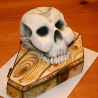 Coffin & Skull The skull is sculpted from the Wilton Sportsball pan. The coffin is a two layer 1/4 sheet cake. Both are covered in MMF and airbrushed with...