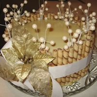 Winter Whites White Chocolate Ganache, French Vanilla cake with White Cream filling. Pirouette Cookie border on sides. Pearl Accents