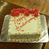 Love red and white anniversary cake. Red roses with icing hearts all around