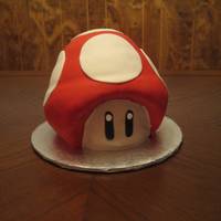 Super Mario Bros This is the mushroom from Super Mario Brothers. Chocolate cake with chocolate buttercream covered in fondant. I used half of the ball pan...