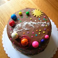 Solar System Cake chocolate cake with cookie and cream filling. The planets are gumballs, the sun is a chocolate transfer and the Milky Way is made with...
