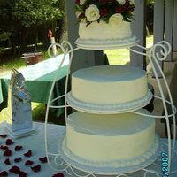 Wedding Cake Three tier cake on a Wilton iron rack. Each layer is a different flavor: bottom, oreo; middle, orange cream; top, strawberry. Icing is...