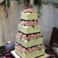 Pink Flowers And Cherry Blossoms 6 8 10 12 inch square cakes with Gumpaste flowers between the tiers. Cake topper is a sugar letter N. Fondant covered cakes with...