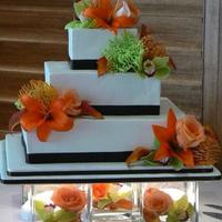 Emily's Cake 5", 7" and 11" square tiers - all different flavors and fillings. Ice with buttercream. Dark brown satin ribbon. Florist...