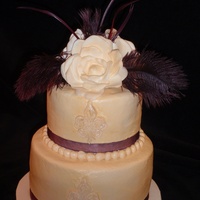 Michelle Ivory buttercream with fleur de lis, gardenia and eggplant feather topper