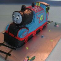 Thomas Tank This was done for a four year old's birthday. Sculpted chocolate cake, banana crema filler. Buttercream with MMF accents. MMF face....
