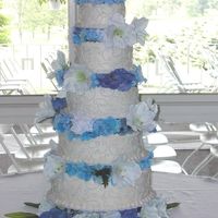 Nikki's Cake Five tier buttercream with center pillar construction, silk flower rings & blue buttercream scroll design.