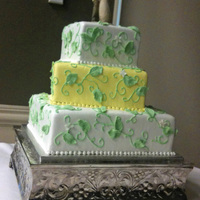 Katie 6/10/14 square. Buttercream icing, piped vines adn sugar leaves with a few sugar flowers. i wasn't too sure about the middle tier...