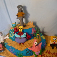 Sponge Bob And Friends Two tier cake covered in MMF. Flowers and jelly fish are buttercream. Leaves, shovel and pail are candy melts. Graham cracker crumb sand...