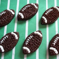 Football Brownies Brownies cut out with a football shaped cookie cutter. Decorated with buttercream icing.