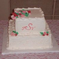 Anniversary Cake This is a 12" and an 8" square cake. White with white buttercream. Flowers are mmf.