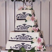 Schimdt Wedding This is a 6,8,12,14 square cake. Iced in buttercream with buttercream stenciling. The flowers are mmf completely edible, no wire at all.