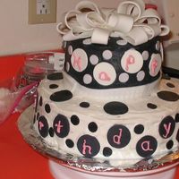 Black & White Birthday Cake Two tiered cake with buttercream frosting and fondant black & white dots. Bow is fondant.