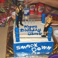 Wrestling Ring Square cake covered in fondant with plastic dowel rods on each corner covered in fondant elastic rope around the dowel rods.