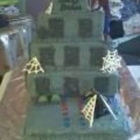 Spiderman Cake covered in buttercream icing colored gray. windows and webs made out of royal icing. Toy spiderman and enemy