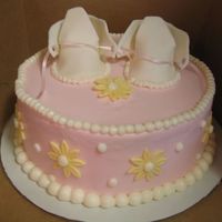 Baby Shoes This is a White Chocolate cake with Strawberry Buttercream Icing.Gumpaste Baby Booties and MMF Daisies
