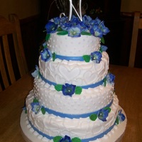 Shasta 4 tier Buttercream icing with fondant accent and large gumpaste hydrangea flowers.Vanilla, Strawberry, Red Velvet and Vanilla Cake.