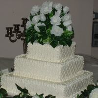 Pb271056.jpg My first wedding cake two years ago. I didn't know how to do floralarrangements, so I purchased a flower for the top. I used edible...