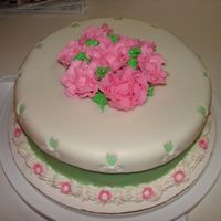 Pink Roses Special Birthday cake for a friend. Pink roses, green & white fondant base with flower cutouts. Small fondant flowers used on border...