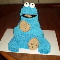 Cookie Monster yellow cake covered with buttercream cookies are chocolate chip