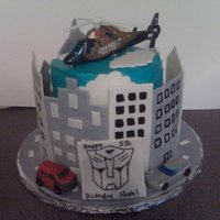 Transformers Birthday Cake! two tiered birthday cake with fondant/gumpaste buildings and road. Transformers birthday cake!