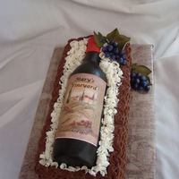 Wine Bottle Basket Gumpaste wine bottle on chocolate cake with choc buttercream for basket-- Fondant grapes and leaves.