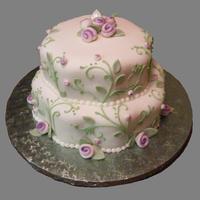 Karrie's Petal Cake pearlized roses and leaves on rolled fondant has a delicate look on this petal shaped cake