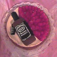 Cheese Cake With Jack Chocolate Bottle this is a plain cheese cake with a chocolate Jack bottle on top with a tiny store bought candy bottle next to it.