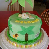 Jungle Baby Shower Orange cake covered in fondant. Fondant baby and animal cutouts. Plam tree made from gumpaste and fondant covered dowel.