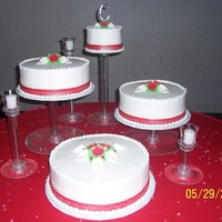 Brittney's Cake Cakes are iced in buttercream and decorated with a fondant ribbon and royal icing calla liliys and roses.